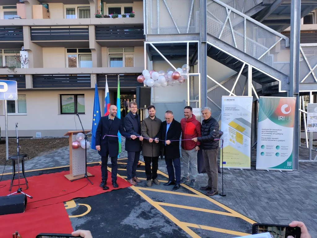 Project representatives cutting the ribbon outside the Ob Suhi 19 apartment building in 2025